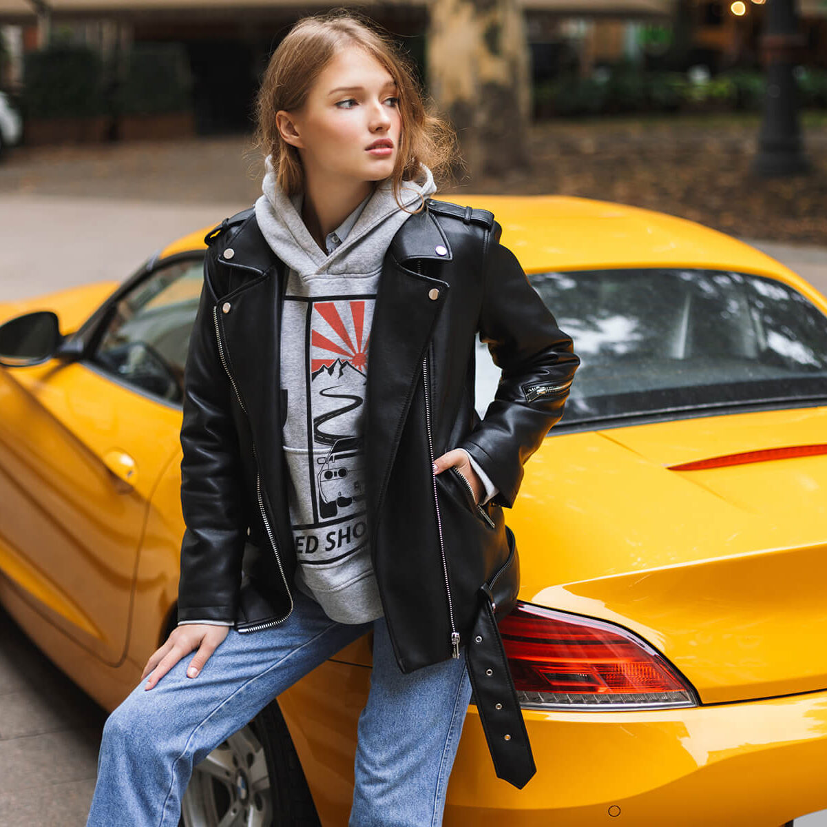 young-beautiful-woman-leather-jacket-leaning-yellow-sport-car-while-thoughtfully